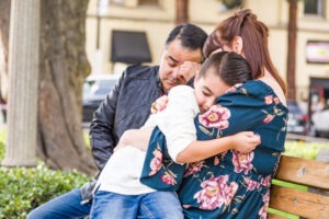 family with child sits in park and mourns wrongful death