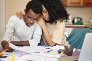 sad woman and man look at bills after suing for wrongful death